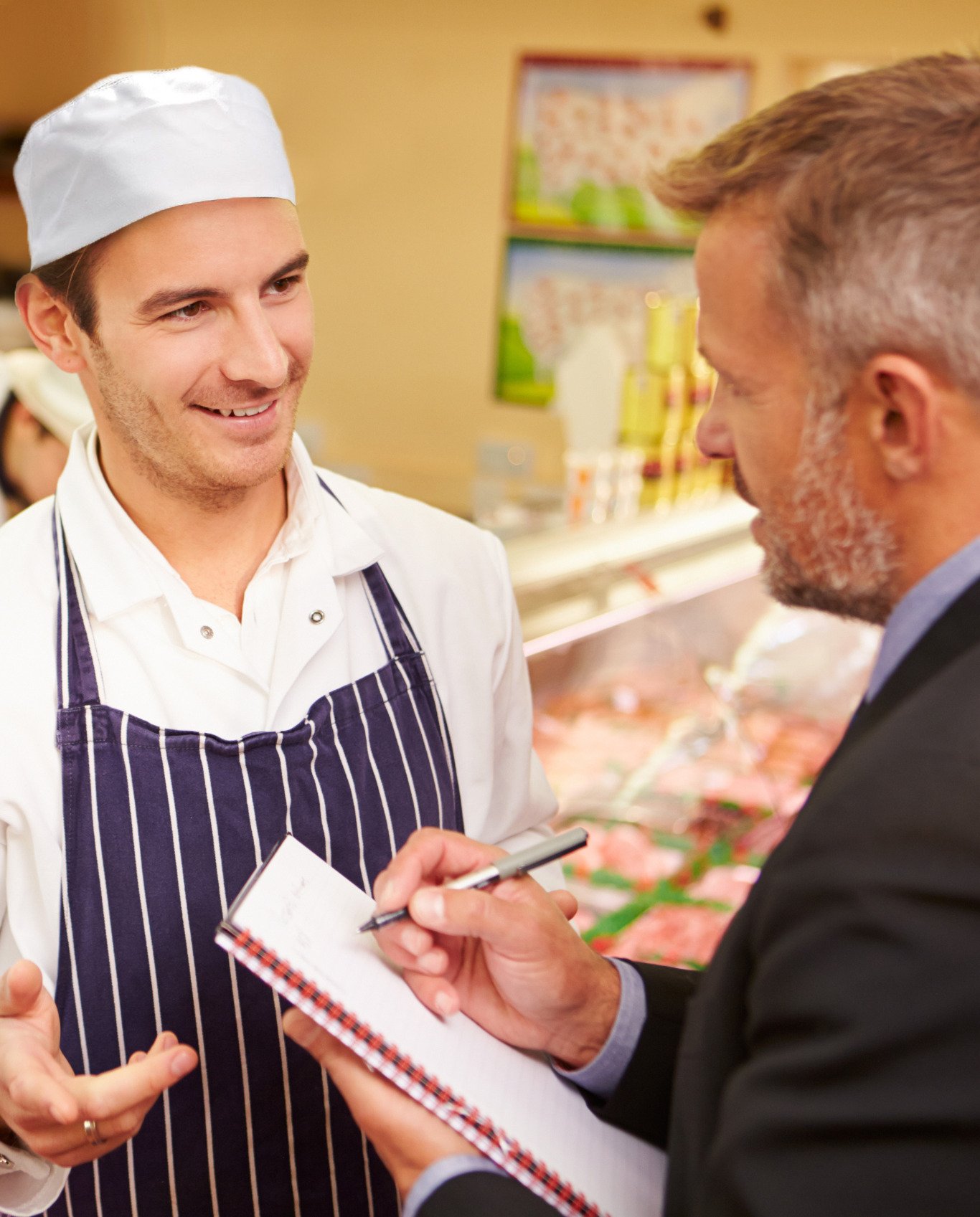 A researcher talks to a deli worker in a supermarket